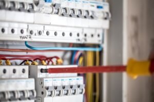 man-electrical-technician-working-switchboard-with-fuses-installation-connection-electrical-equipment-close-up_169016-5074